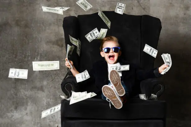Nevető napszemüveges gyerek fekete fotelben, bankjegy eső, öröklési jog