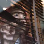 Redőny mögül kinéző vörös hajú nő, személyi jog