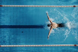 Versenymedencében úszó férfi, versenyjog